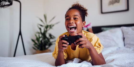 Cheerful young African American girl playing video games
