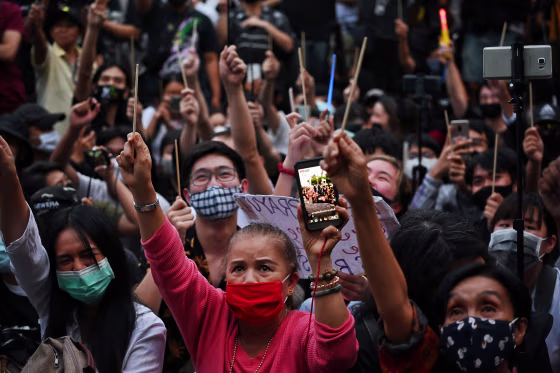 Image: Protesters hold wands in the air during a Harry Potter-themed anti-government rally at the Democracy Monument in Bangkok