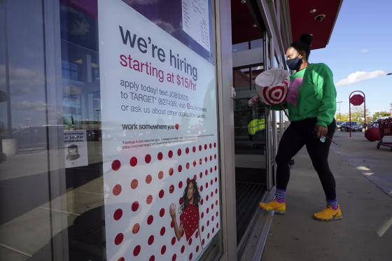 Image: A passerby walks past a hiring sign while entering a Target store in Westwood, Mass. Sept. 30, 2020.
