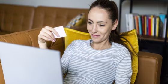 Young woman on couch at home shopping online