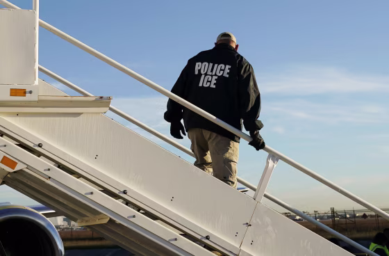 An officer watches as immigrants who entered the United States illegally are deported on a flight to El Salvador by U.S. Immigration and Customs Enforcement in Houston.