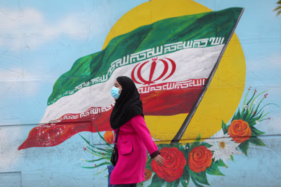 Image: An Iranian woman wearing a face mask walks on a street after Iranian authorities made it mandatory for all to wear face mask in public following the outbreak of the coronavirus disease (COVID19), in Tehran