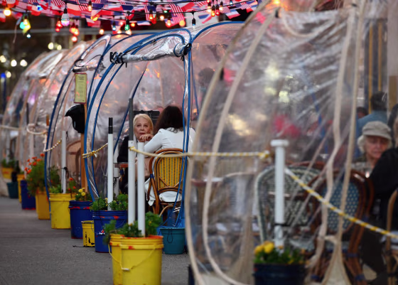 Diners eat outdoors in plastic tents at a restaurant in New York on Oct. 15, 2020.