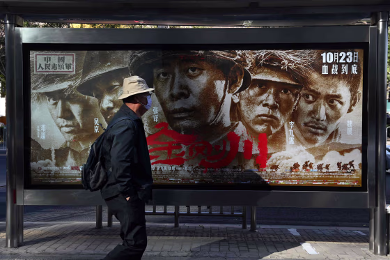 Image: A man walks past a poster for the movie \"Sacrifice\", about China's entry into the 1950-1953 Korean War to fight alongside North Korea against the U.S., in Beijing
