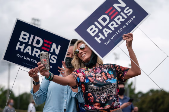 Image: Two women holding Biden/Harris lawns signs take a selfie at a rally with Democratic Senate candidates Rev. Raphael Warnock and Jon Ossoff on Oct. 24, 2020, in Duluth, Georgia.