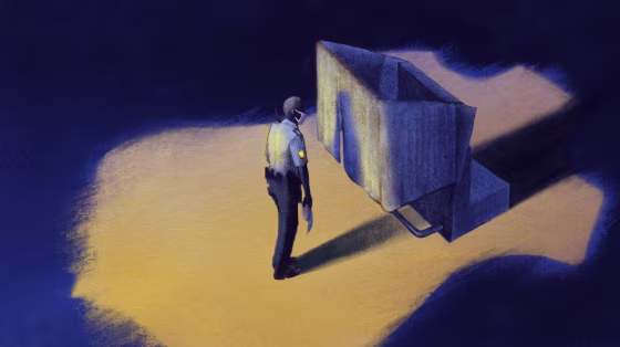 Image: A police officer waits to cast a ballot while the spotlight in the shape of a police badge illuminates him.