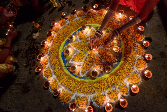 Woman hand lighting diyas during diwali,Varanasi,Uttar Pradesh,India.