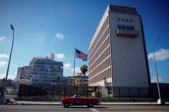 Tourists in a vintage car pass by the U.S. Embassy in Havana