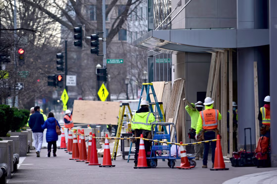 Image: Workers board up the buildings near the White House prior to the presidential inauguration in Washington