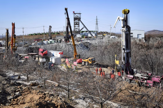 Image: Members of a rescue team work at the site of a gold mine explosion where 22 miners are trapped underground in Qixia, in eastern China's Shandong province