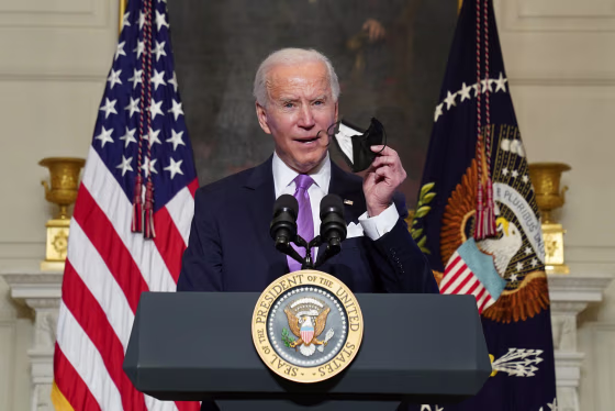 Image:President Joe Biden holds up a face mask as he speaks about the fight to contain the Covid-19 pandemic, at the White House.