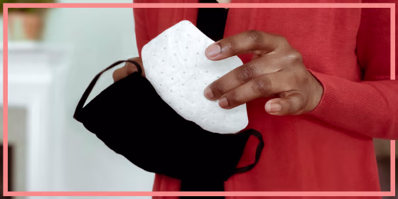 Woman replacing a face mask filter in her cloth facemask