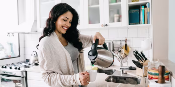 Young adult woman filling a cup of coffee