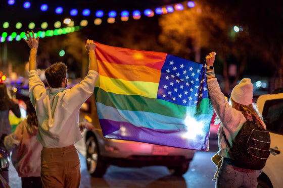 People wave a rainbow flag as they celebrate the presidential election in West Hollywood, Calif., on Nov. 7, 2020.