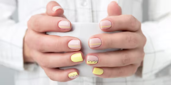 Woman with trendy manicure design holding a coffee mug