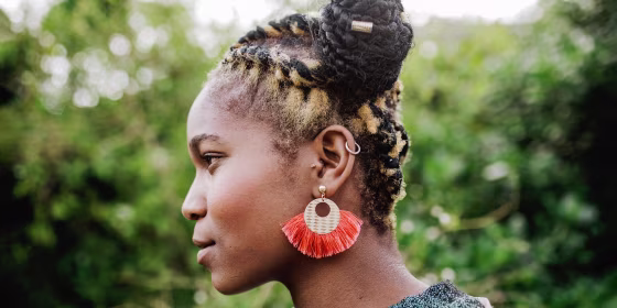 Side profile of a Woman outside, wearing a beautiful orange earring