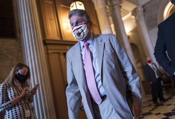 Image: Joe Manchin leaves the Senate chamber on March 11, 2021.