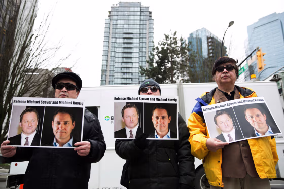 Image: Protesters hold photos of Canadians Michael Spavor and Michael Kovrig, who are being detained by China, outside British Columbia Supreme Court, in Vancouver.