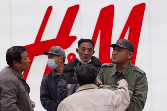 Image: Migrant workers gather near an H&M store in Beijing