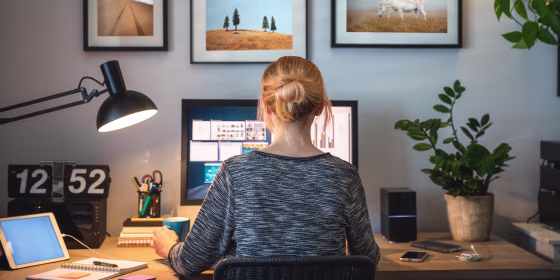 Woman sitting at her work from home desk, surrounded by desk accessories
