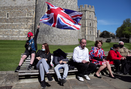 Image: People sit outside Windsor Castle on the day of the funeral of Britain's Prince Philip, husband of Queen Elizabeth, who died at the age of 99, in Windsor, near London