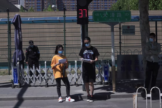 Image: Residents pass near the U.S. consular services outside the U.S. Embassy in Beijing