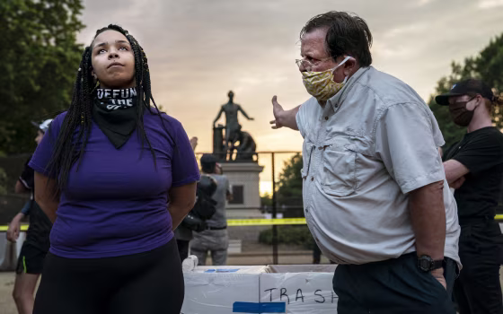 Anais, 26, who wants to remove the Emancipation statue in Lincoln Park in Washington argues with a man who wants to keep it on June 25th, 2020.