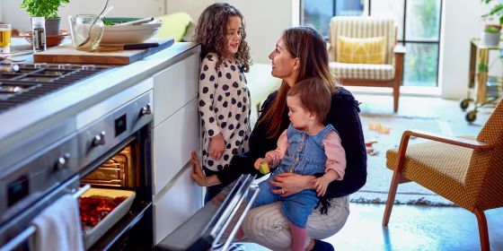 Mother cooking at home with two children