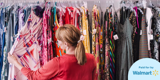 Woman looking at dress hanging on rack while standing at store