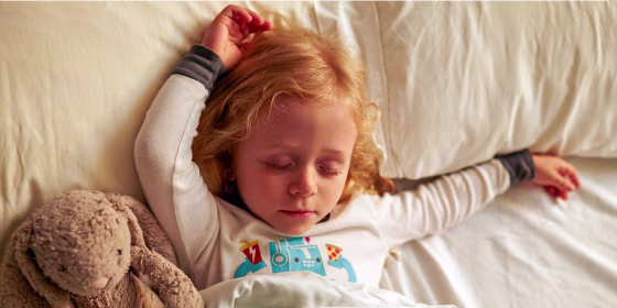 Young girl sleeping with stuffed rabbit