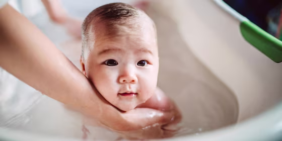 New born baby having tub bath joyfully