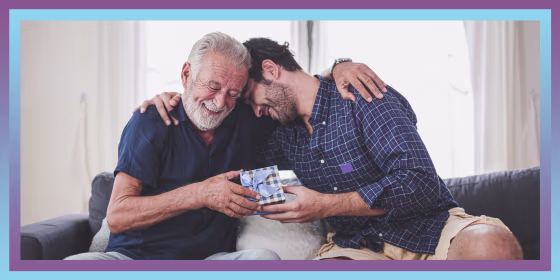 Son Giving Father Gift While Sitting On Sofa At Home