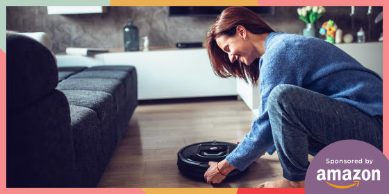 Woman holding a robot vacuum in her living room