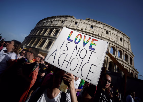 Image: Participants walk past the Colosseum monument in the Italian capital Rome during the annual Gay Pride parade.
