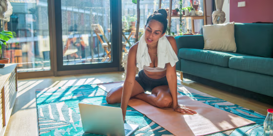A young sports woman exercising using a laptop