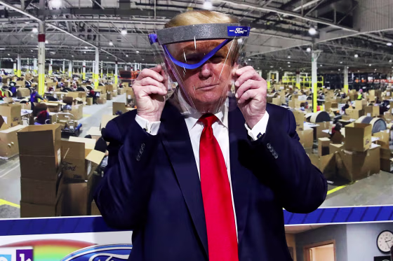 President Donald Trump holds up a protective face shield that was handed to him during a tour at the Ford Rawsonville Components Plant in Ypsilanti, Mich., on May 21, 2020.
