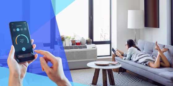 Woman reading book while lying on sofa at home in front of her AC and a hand controlling AC on their phone. The best smart air conditioners allow you to control temperature over Wi-Fi, remotely using apps, or with voice assistants. Shop Honeywell, LG and