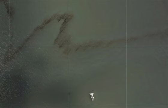 Image: A dark trail appears on the waters of the Gulf of Mexico near an oil industry platform