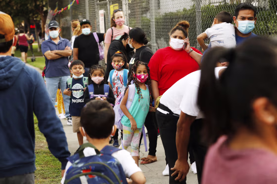 Parents and students wait in line to check pre-approved health clearances in order to enter Lankershim Elementary School in North Hollywood, Calif., on Aug. 17, 2021.
