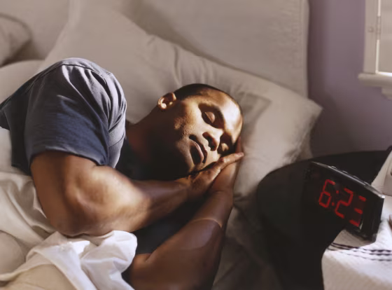 Image: Alarm clock next to man sleeping