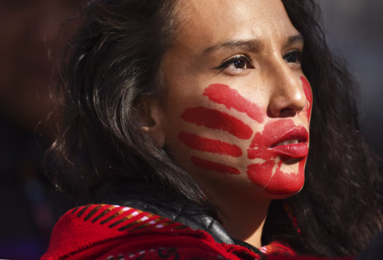 Micaela Iron Shell has painted red hands over their mouth to show solidarity for missing and murdered indigenous, Black and migrant women and children during a rally on Oct. 11, 2019, in Denver.