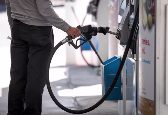 Image: A person holds a fuel pump nozzle at a Chevron Corp. gas station in Colma, Calif.