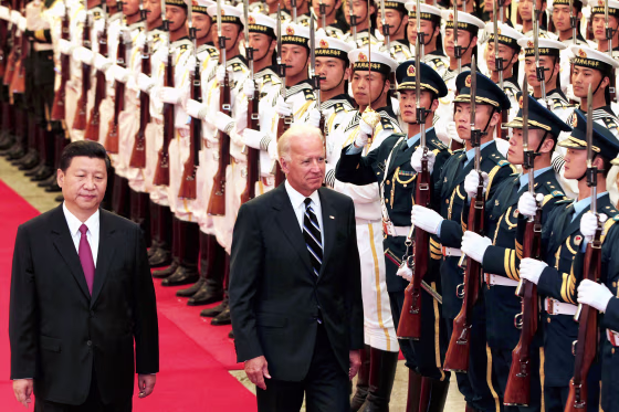 China's then-Vice President Xi Jinping accompanies then-Vice President Joe Biden to view an honor guard during a welcoming ceremony in Beijing on Aug. 18, 2011.