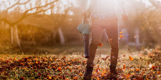 Portrait of man blowing leaves using a leaf blower