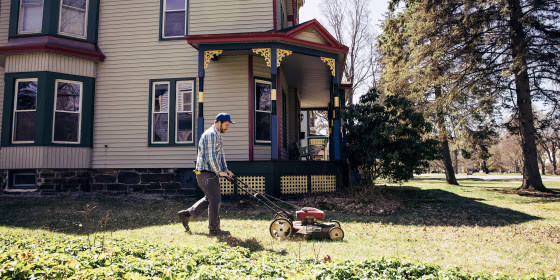 Mature man mowing grass on sunny day