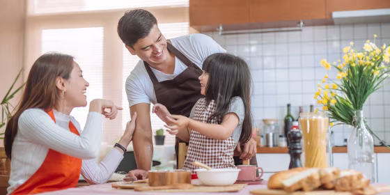 Family preparing to bake in a kitchen wearing aprons