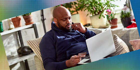Man online shopping on sofa with laptop