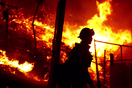 A firefighter battles the Alisal fire along the 101 Freeway near Goleta, Calif., on Oct. 12, 2021.