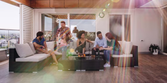 Happy friends enjoying in drinks and conversation on a penthouse balcon
