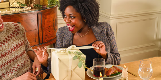 Woman opening a gift at the table